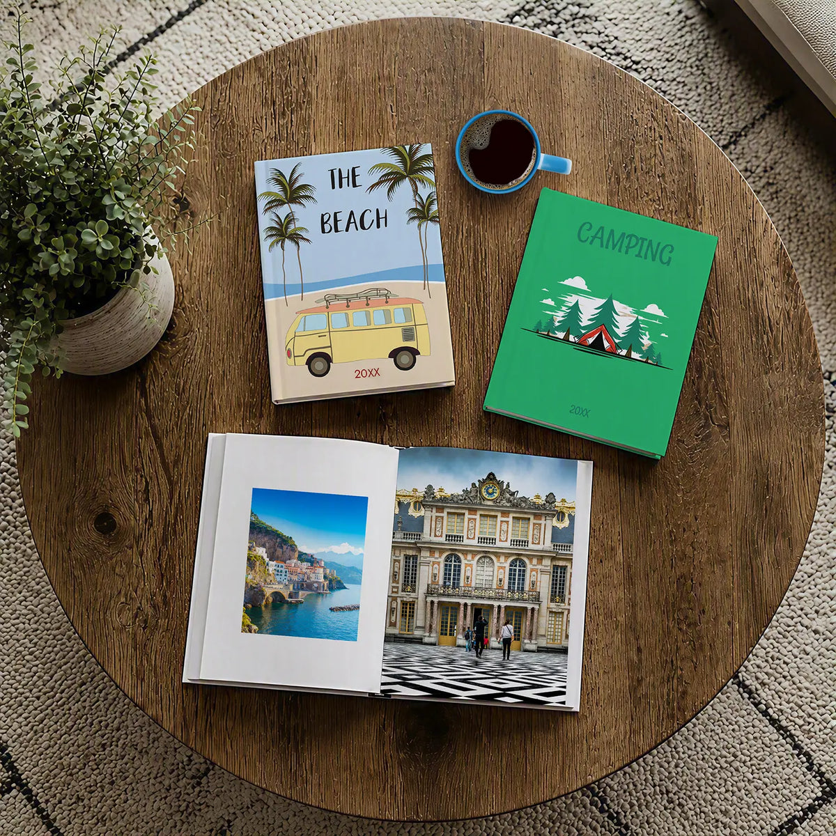 Beach and camping photo books beside an open travel album on a wooden coffee table.