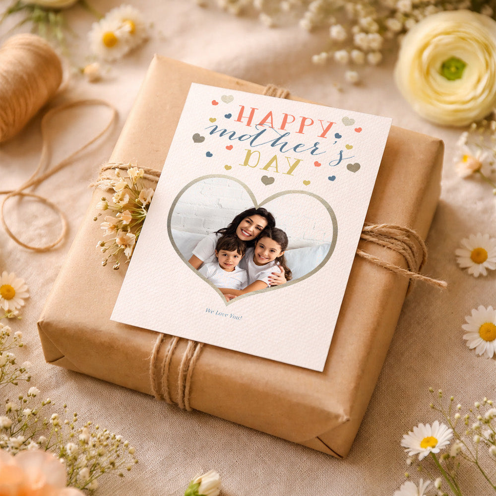 Gift wrapped in brown paper with a 'Happy Mother's Day' card featuring a photo of a family, surrounded by flowers.