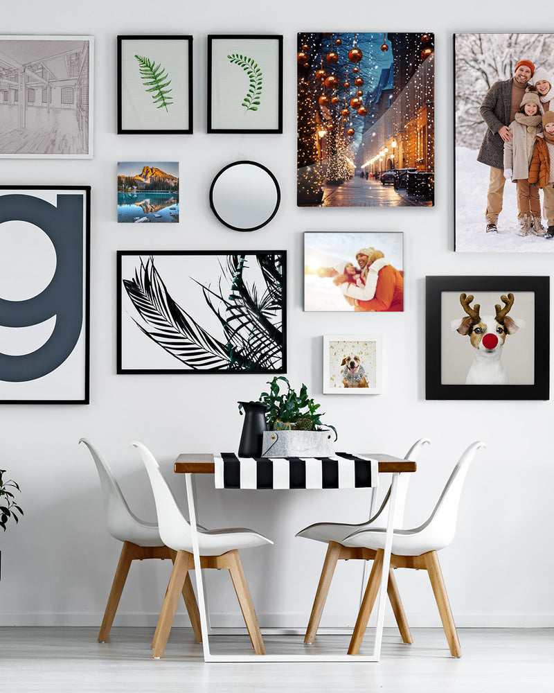 Dining room with a wall of framed pictures and a table with chairs.