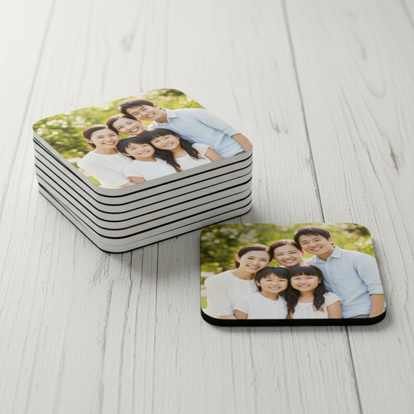 Stack of personalized family photo coasters on a wooden surface